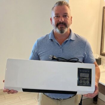 A man in his living area with the BlizzAir unit